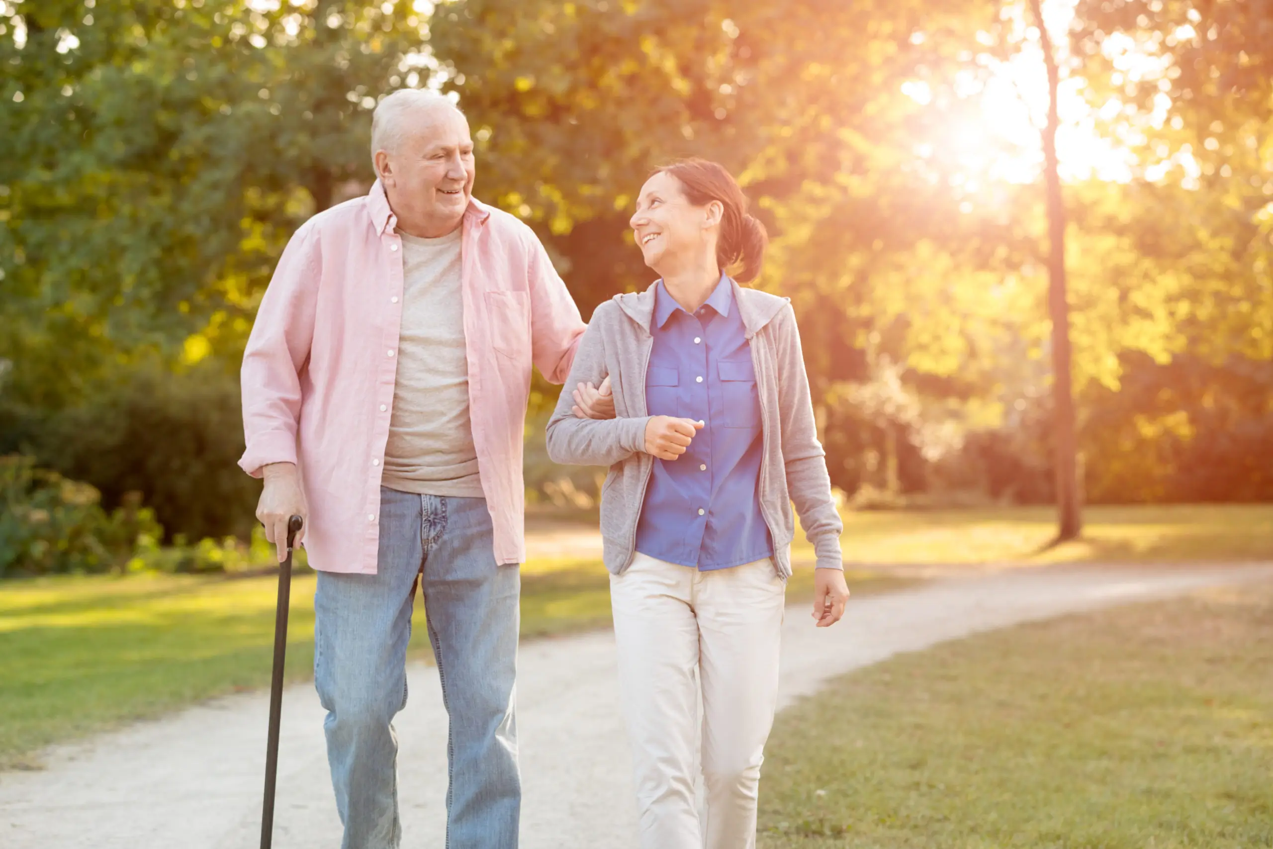 Bild von Senior in Begleitung im Park beim Spazieren